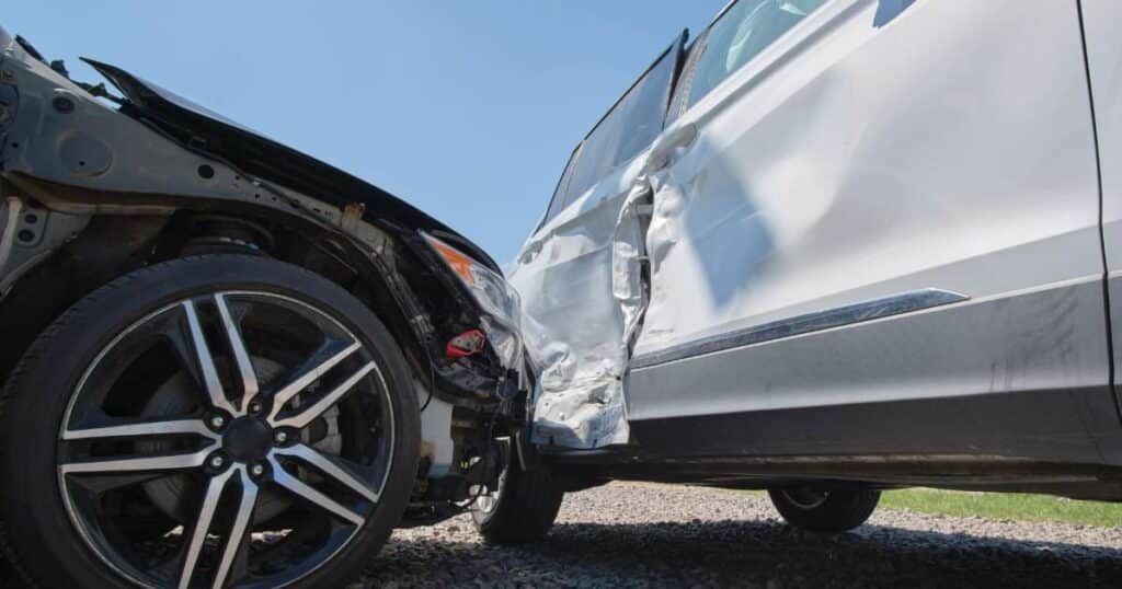 A damaged car after a sideswipe accident, showing significant dents and scratches on the side panels.