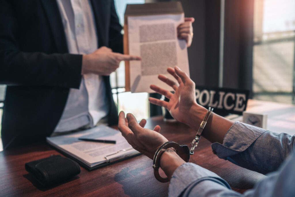 A man holds a document while another person prepares to sign it with a pen, discussing wrongful death lawsuits.