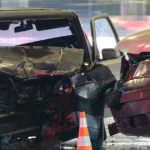 A damaged car from a T-bone accident, showing significant impact on the side and crumpled metal