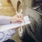 Insurance adjuster recording damage after accident for rate increase